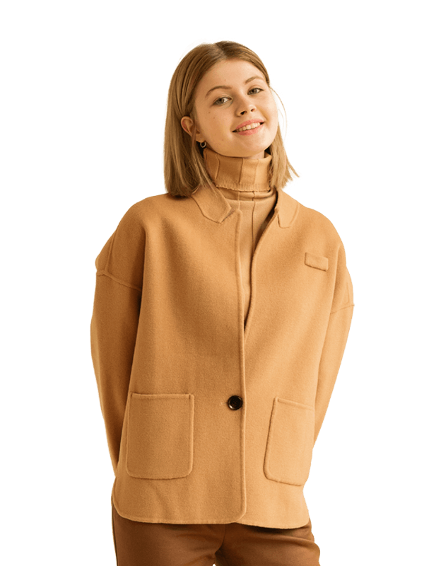 A confident women influencer wearing a wool camel coat with a collar, smiling brightly.